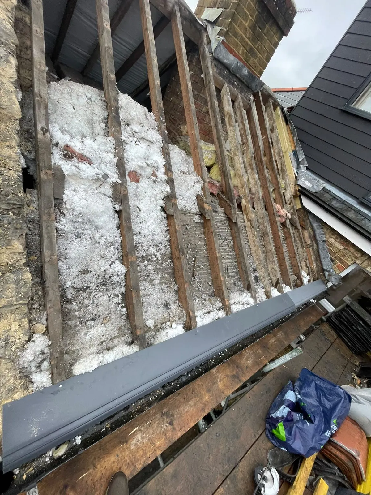 Roof stripped back showing old battens and insulation