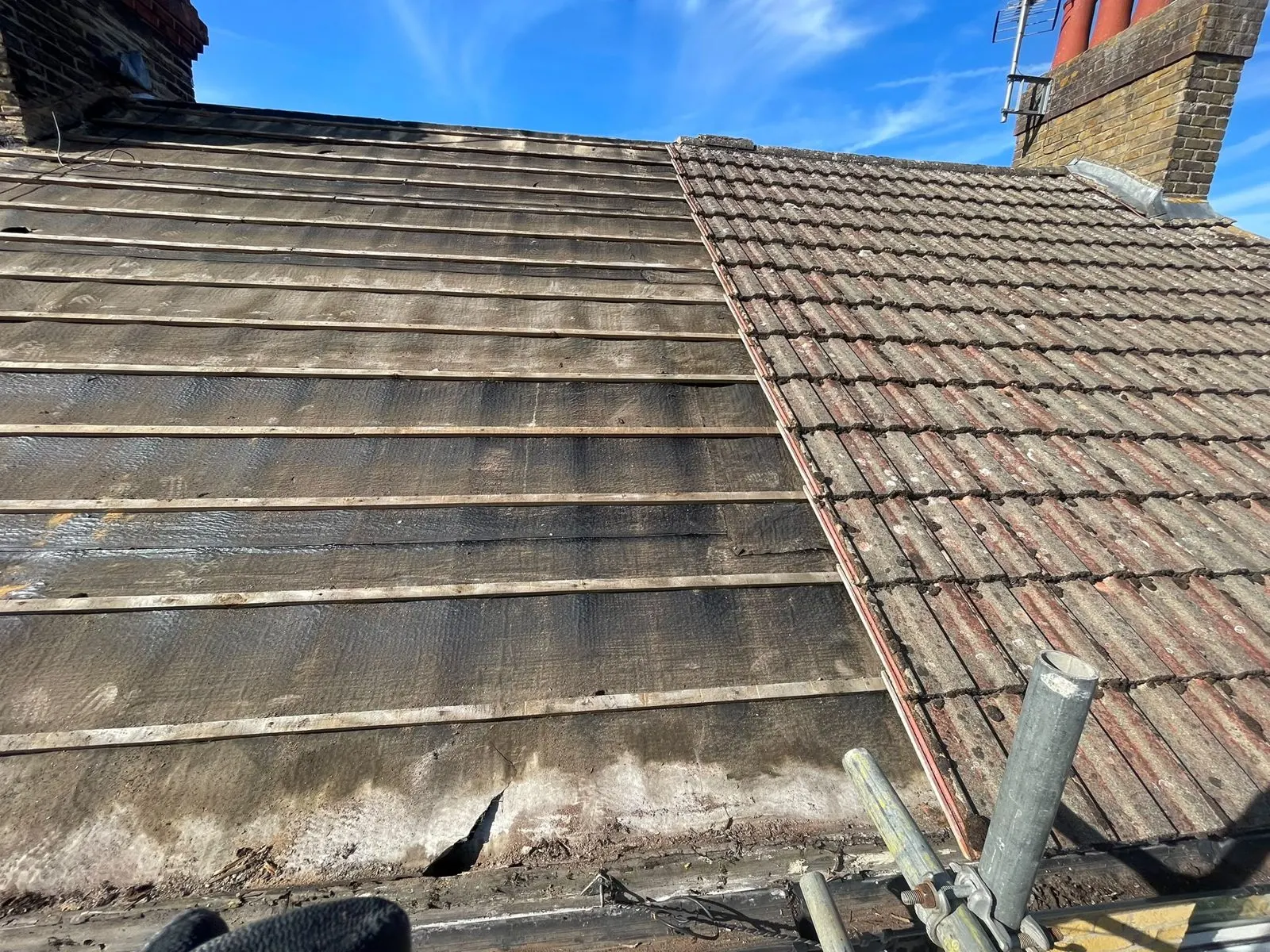 Worn tiled roof with stained, perished tiles