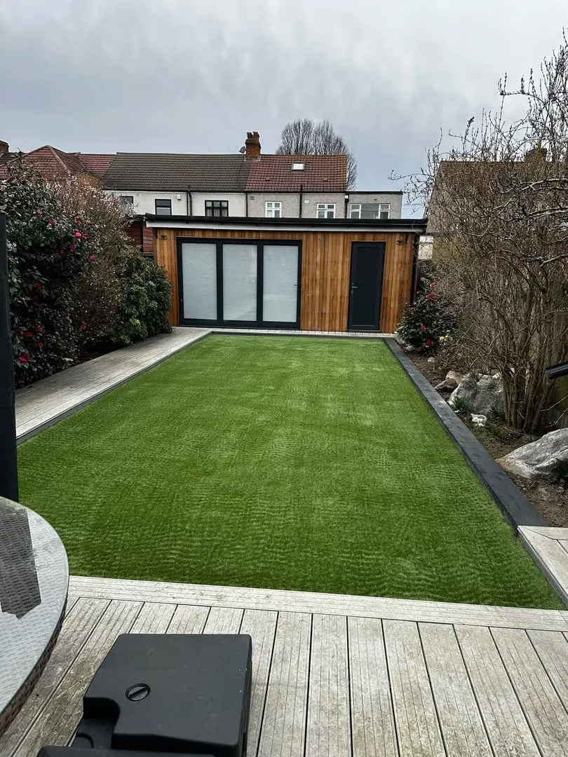 Garden room with decking and an artificial lawn